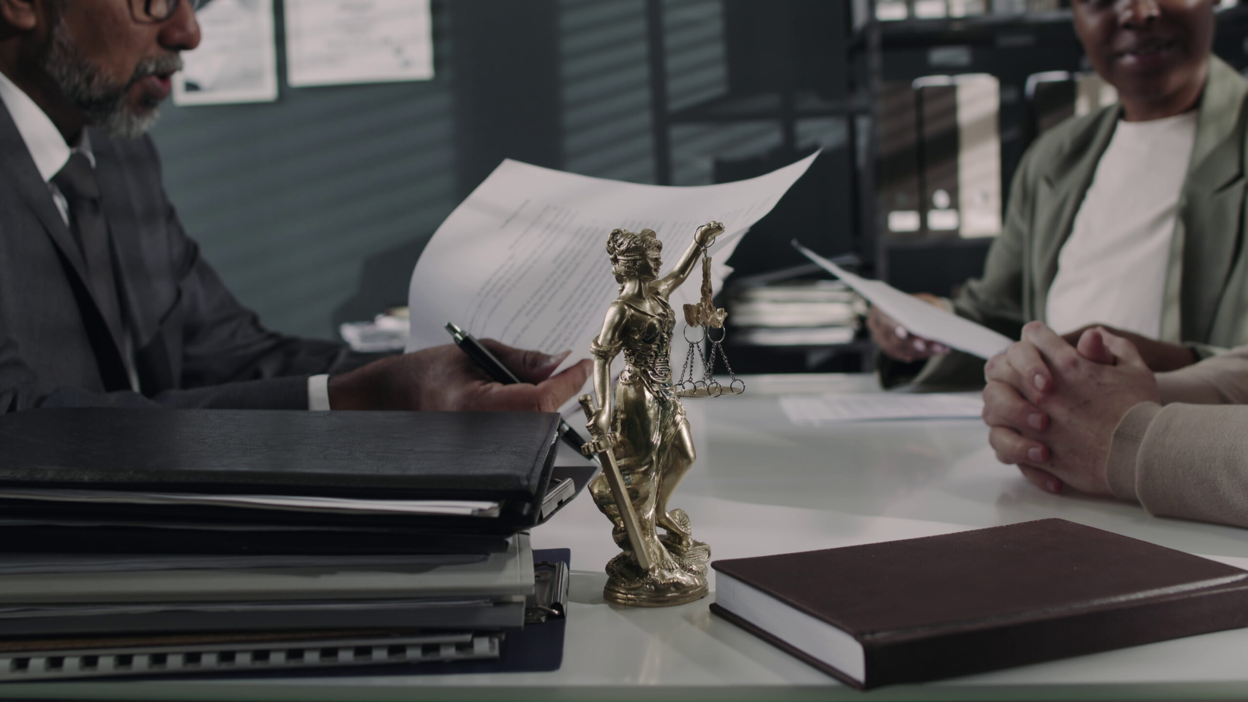 Family lawyers Adelaide consulting a couple with a Themis statue on the table.